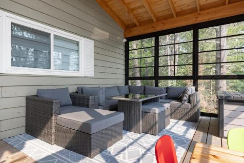 a patio with wicker furniture and a table at Muskoka Gem 8ppfireplacescanoekayaks in Bracebridge