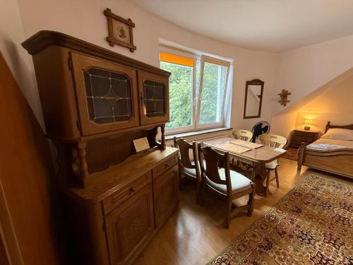 a living room with a large wooden cabinet and a table at VITA Augustów in Augustów