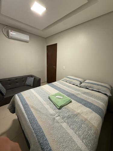 a bedroom with a bed with a green towel on it at Apartamento Frente à Praia da Graciosa in Palmas
