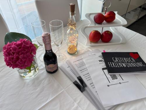 a table with a bottle of wine and flowers and glasses at Auszeit in Volkertshausen