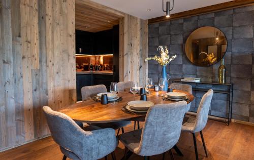 a dining room with a wooden table and chairs at Hôtel L'Arboisie in Megève