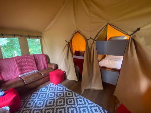 a living room with a couch in a tent at Cefn Crib Safari Tent in Machynlleth