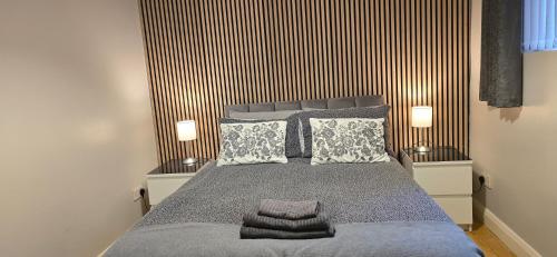 a bedroom with a large bed with two lamps at Alexandra Park Apartments in Belfast