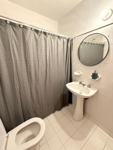 a bathroom with a toilet and a sink and a mirror at Dto centro RG in Bahía Blanca