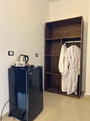 a room with a closet with a white shirt and a shirt at Are Pyramids View in Cairo
