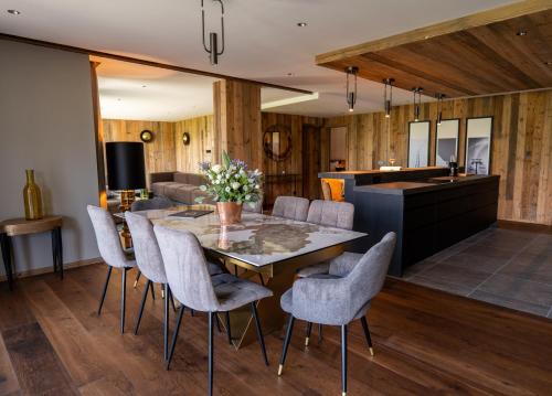 a kitchen and dining room with a table and chairs at Hôtel L'Arboisie in Megève