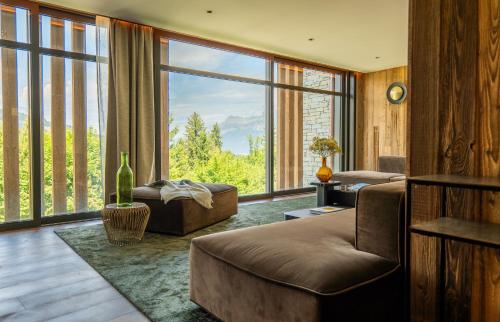 a living room with a couch and a large window at Hôtel L'Arboisie in Megève