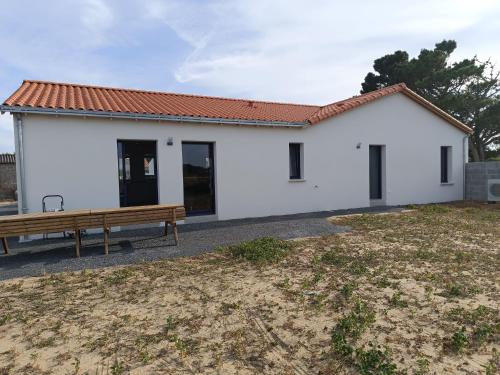 a white house with a bench in front of it at L'écrin des Marais in Les Sables-dʼOlonne