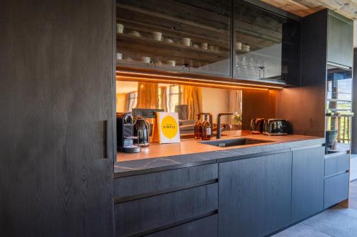 a kitchen with a sink and a counter top at Hôtel L'Arboisie in Megève