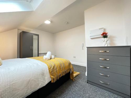 a bedroom with a bed and a dresser at Urban Nest Ilkeston in Ilkeston