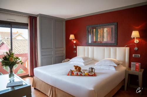 a bedroom with a bed with a tray of food on it at Georges Blanc Parc & Spa in Vonnas