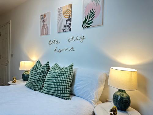 a bedroom with a bed with pillows and a sign that reads its stay home at Urban Nest Ilkeston in Ilkeston