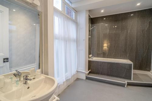 a bathroom with a tub and a sink and a shower at The Grand Scarborough in Scarborough
