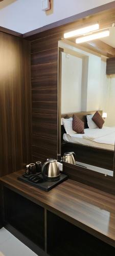 クンダプラにあるHotel SAVI SAGARの鏡付きのカウンターとベッドのあるキッチン