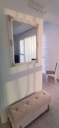a mirror on a wall with a couch in a room at Studio Meraki Resort and Spa in Mamaia Nord