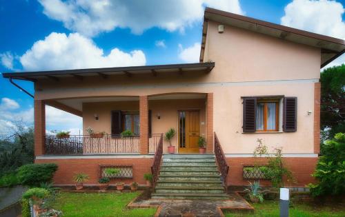a house with a staircase in front of it at House in the Tuscan countryside in Lazzeretto