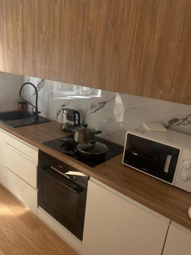 a kitchen with a stove and a microwave on a counter at 2 комнатная квартира золотой квадрат ЖК Москва in Astana