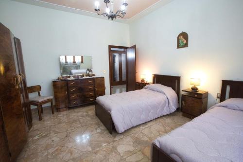 a bedroom with two beds and a sink and a mirror at House in the Tuscan countryside in Lazzeretto