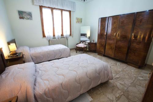a bedroom with a large bed and a large wooden cabinet at House in the Tuscan countryside in Lazzeretto