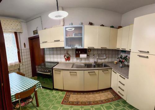 a kitchen with white cabinets and a sink and a table at House in the Tuscan countryside in Lazzeretto