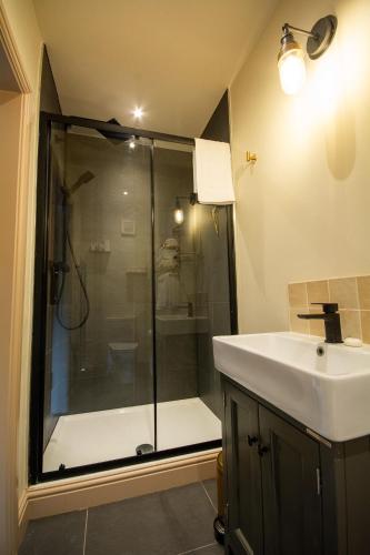 a bathroom with a shower and a sink at Bolesworth Bothy in Tattenhall