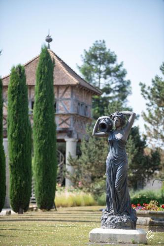 a statue of a woman taking a picture of a house at Georges Blanc Parc & Spa in Vonnas