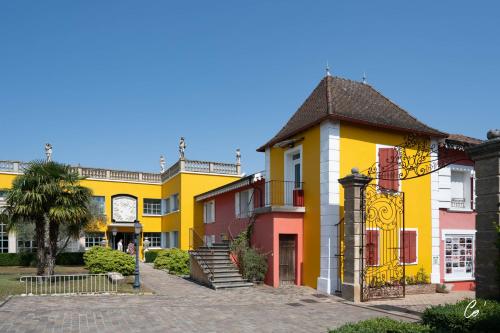a row of colorful buildings with a palm tree at Georges Blanc Parc & Spa in Vonnas