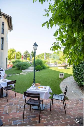 a patio with two tables and a street light at Georges Blanc Parc & Spa in Vonnas