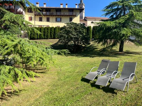 two chairs sitting in the grass in a yard at Casa Miravalle Mountain Apartments in Enguiso