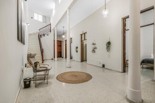 a hallway with a chair and a rug on the floor at Casa Caraish Arucas Rooms in Arucas