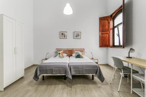 a bedroom with a bed and a table and a desk at Casa Caraish Arucas Rooms in Arucas