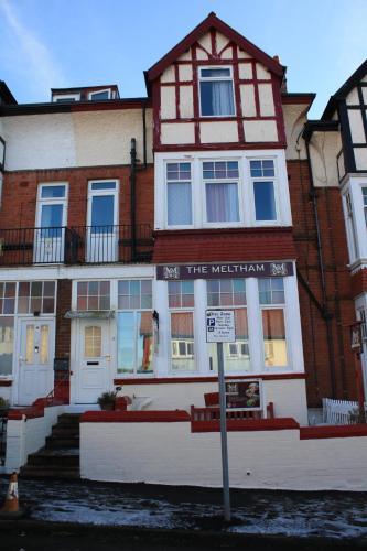 a red and white building with a sign in front of it at The Meltham Guesthouse Scarborough in Scarborough