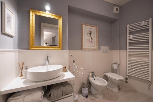 a bathroom with a sink and a toilet and a mirror at Incantevole loft in centro in Perugia
