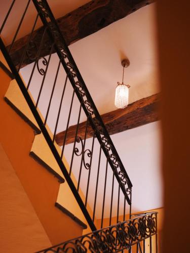 a staircase in a house with a chandelier at Hôtel U Palazzu & Spa in Venaco