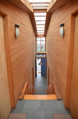 a hallway of a building with wooden walls and benches at Palafito Azul Apart Hotel in Castro