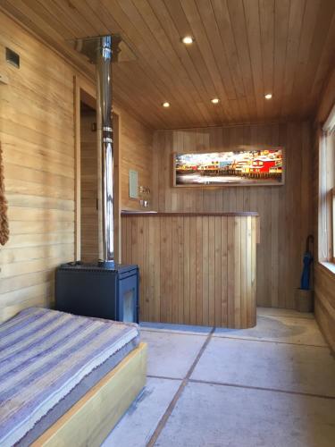 a sauna with a bed and a tv on the wall at Palafito Azul Apart Hotel in Castro