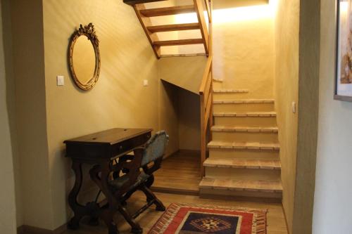 a hallway with a table and stairs with a mirror at Val di Codena - Holiday Home in Vetto