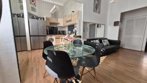 - un salon avec une table en verre et des chaises noires dans l'établissement Centre Carré d'or 3 chambres, à Cannes