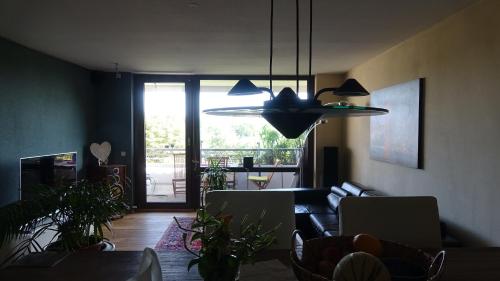 a living room with a couch and a pendant light at Guestroom with wide view and pool near city side, 2nd guest with extra bed possible in Frankfurt/Main