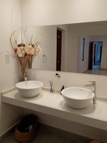 a bathroom with two white sinks and a mirror at Ribera I in Cafayate