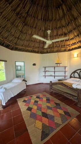 a bedroom with two beds and a rug on the floor at Punta Manzanillo in San Bernardo del Viento