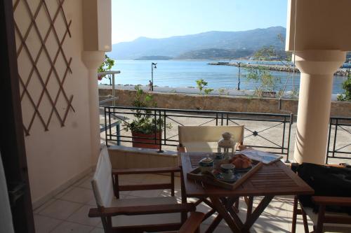 a table and chairs on a balcony with a view of the water at Rena's Guesthouse, by Comfortbnb in Sitia
