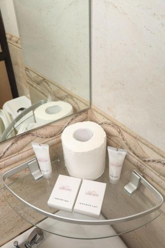 a glass table with a toilet and a mirror at Lowlands Hotel & Spa in Chuka