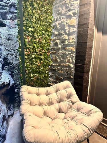 a white tufted couch sitting on a patio at Secret Rock - Jaccuzi privé in La Roche-en-Ardenne