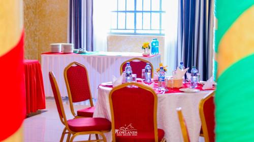 a table with red chairs and a white table cloth at Lowlands Hotel & Spa in Chuka