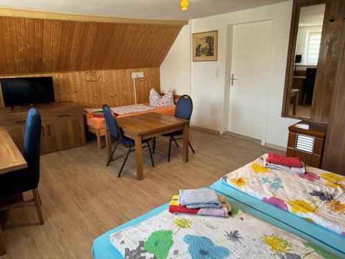 a room with two beds and a table and a dining room at Memleben Lützower 12 in Kaiserpfalz