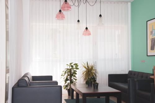 a living room with two couches and a table at Garner Hotel Cologne Porz - Airport by IHG in Cologne