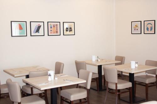 a dining room with tables and chairs and pictures on the wall at Garner Hotel Cologne Porz - Airport by IHG in Cologne