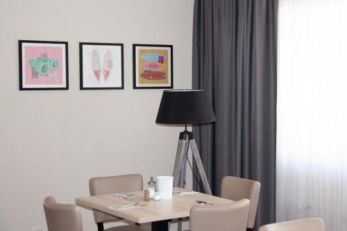 a dining room table with chairs and a lamp at Garner Hotel Cologne Porz - Airport by IHG in Cologne