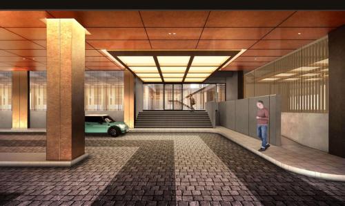a man standing in a hallway with a car in a building at voco Bangkok Surawong by IHG in Bangkok